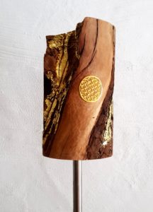 Gebetsmühle aus Birnenholz in gewachsener Form mit Lebensblume in Blattgold auf einem Bodenständer aus Edelstahl